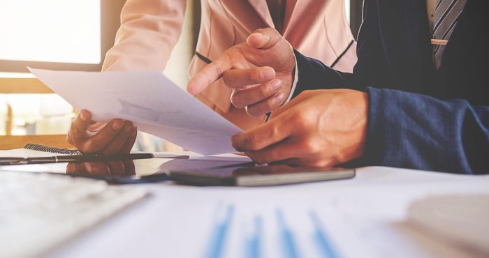 Business concept. Business people discussing the charts and graphs showing the results of their successful teamwork. Selective focus.